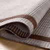 Detailed close-up of rug fold highlighting durable woven edges and coffee brown stripe