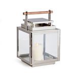 Adwin outdoor lantern with polished chrome frame, wide glass panes, and natural teak handle holding white pillar candle
