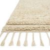 Close-up of rug’s plush shag texture and tasseled fringe detail in light oatmeal color