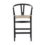 Side angle showing front black teak leg and woven seat edge