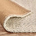 Rug corner flipped over revealing soft backing and jute knitting underneath