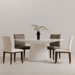 Styled setting with Otago Oval Dining Table paired with mix of white and taupe dining chairs against plain backdrop