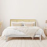 Styled bedroom setting with Haven Woven Bed dressed in white and beige bedding on light wood floor