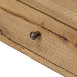 Close-up of round brushed brass button hardware on nightstand drawer