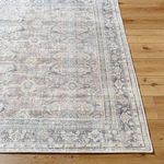Top corner perspective of Darling Charcoal Rug highlighting border details and distressed finish on hardwood flooring