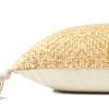 Side view of pillow showing thickness and cream-colored back fabric with tassel detail