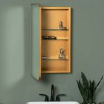 Opened cabinet door with visible glass shelves holding decorative items against sage green wall