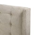 Close-up of tufted headboard edge with fabric texture and stitching on linen upholstery
