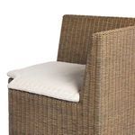 Side view of bench showing natural woven rattan frame and fabric seat cushion