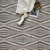 Section of the rug with styling detail including a cream throw, book, and decorative bowl on top