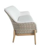 Side profile emphasizing curved wicker armrest and smooth white vinyl seat cushions