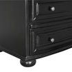 Close-up view of bottom corner showing rounded bun foot and beveled drawer edges