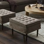 Living room scene with two tufted Ottomans featuring stripe fabric and dark tapered wood legs on area rug