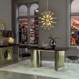 Room setting with Baran Barrel Back Chair paired with brass and dark wood dining table under warm pendant light