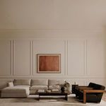 Wide living room scene showing Rue Ottoman integrated into sectional sofa with dark wood furniture and cream walls