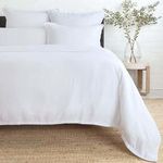 White Georgie Bamboo Linen Duvet on bed with soft, smooth drape over natural fiber rug and simple bedside table