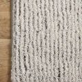 Close-up of rug corner showing pile texture and subtle grey tones near edge