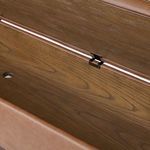 Close-up of interior oak storage compartment showing hinge attachment and wood finish