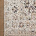 Corner of the rug flat on wood floor showing textured pattern and edge binding