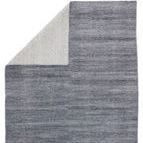 Rug folded over to reveal light gray woven backing contrasting with the front gray-blue pile