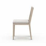 Side view of Sherwood Brown chair in outdoor garden setting next to wooden dining table