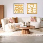 Styled living room setting with the Courtney Sofa Cream accented by pillows, throw, and art