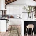 long narrow runner rug placed in bright kitchen with white cabinets and wooden ceiling