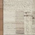 Close-up of rug corner on hardwood floor highlighting intricate patchwork detail and plush textured fibers