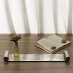 Tray styled on wooden table with small vase and open book with decorative rocks