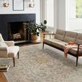 Rosemarie Ivory/Natural Rug styled in a living room with modern beige seating, fireplace, and natural light