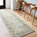 Runner rug placed in a kitchen area with light wood floor and three wooden bar stools