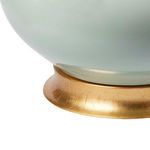 Close-up of the gold-finished circular base showing texture and brush details on the porcelain