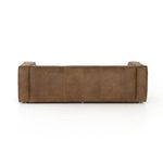 Close-up of arm and seat corner with natural cracks and textured leather on sofa.