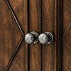 Close-up of round metal knobs on carved diamond patterned wood doors