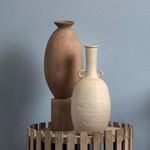 Burnt umber vase paired with off-white textured ceramic vase with handles inside wooden slat decorative basket