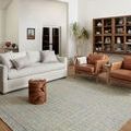 Polly Blue Sand Rug styled in living room with sofa, armchairs, and wood furniture