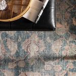 Close-up of rug texture with black leather ottoman and a woven tray on top