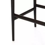 Close-up showing black teak leg support bars in lower frame