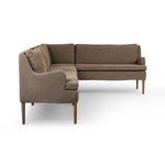 Side profile displaying tapered wooden legs and softly contoured banquette back in brown fabric.