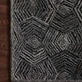 Corner detail of the rug lying on dark wood flooring, highlighting texture and geometric pattern