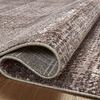 curled corner of rug revealing backside with plaid pattern in lighter colors