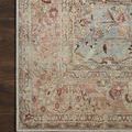 Corner close-up of Adrian Ocean / Clay Rug highlighting intricate floral border on wood floor
