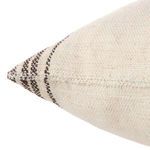 Close-up of pillow corner showing woven texture and brown striped pattern on edge