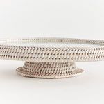 Close-up side profile highlighting thick woven rim and rattan pedestal base