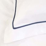 Close-up of navy piping detail on white bamboo sateen pillowcase corner