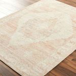 Close-up angled view showcasing woven texture and detailed pattern of Luca dusty pink rug on wood floor