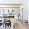 Wynter rug styled in a bright kitchen dining area with light wood table, black chairs, and white cabinetry