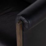 Tightly framed view of leather backrest with central stitching and natural texture
