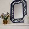 Callista Mirror displayed on a wall above a fireplace with decorative vase and floral arrangement