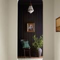 Denim Rug hallway runner styled with dark wall, chair, green plaid pillow, and potted greenery